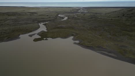 muddy glacier river streaming into atlantic ocean across the valley