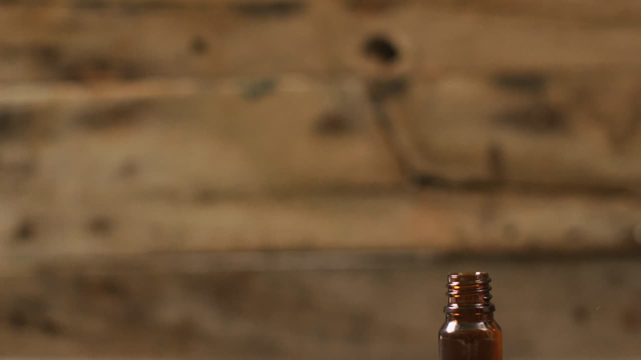 video de brotes de marihuana y una botella de extracto de cbd sobre un fondo de madera