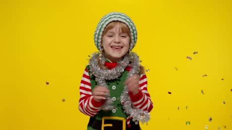 Kid-child-teenager-girl-in-Christmas-elf-Santa-helper-costume-having-fun-rejoices-over-confetti-rain