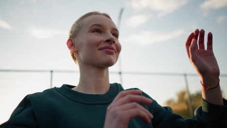 close-up of lady in green sweater playing volleyball outdoors with sunlight creating glow around. intense action shot capturing movement and energy of player during game with warm natural