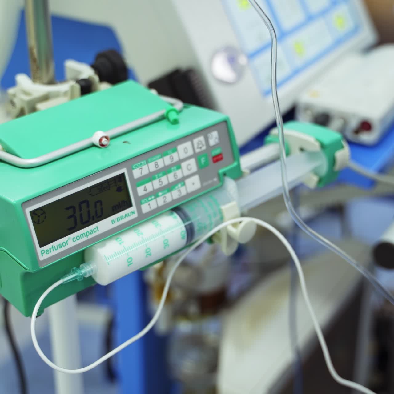 Infusion pump with syringe filled with white medicine. Device for intravenous instills during operation. Close up. Top view