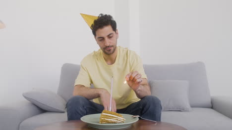un hombre de cabello oscuro celebra su cumpleaños solo