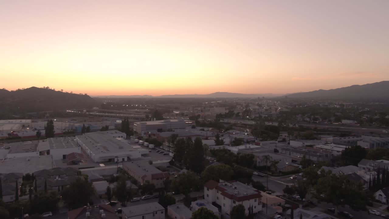 Ripresa aerea in ascesa su Glendale, California, con vista sull'area suburbana e sull'autostrada 134 al tramonto