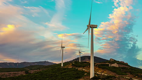 timelapse wind turbines spinning generating electricity with scenic landscape views and clouds moving across the sky during golden hour