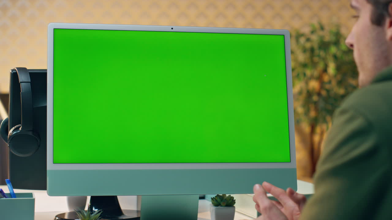 Designer in videochiamata con monitor mockup in ufficio. Uomo in chiamata internet.