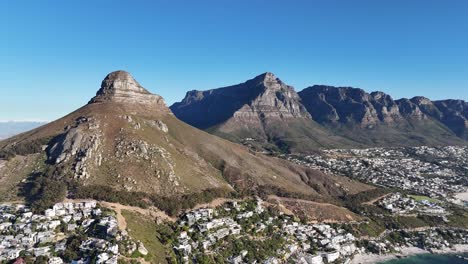 tomada de avión no tripulado que muestra la montaña de la cabeza de león y la montaña de mesa que revela ciudad del cabo, sudáfrica y el océano
