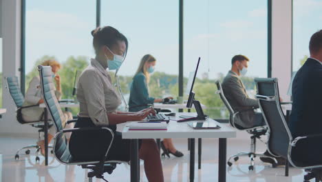 office workers in a modern workplace with masks