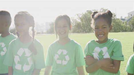 Portrait-of-happy-diverse-schoolchildren-with-recycling-tshirts-at-stadium-in-slow-motion