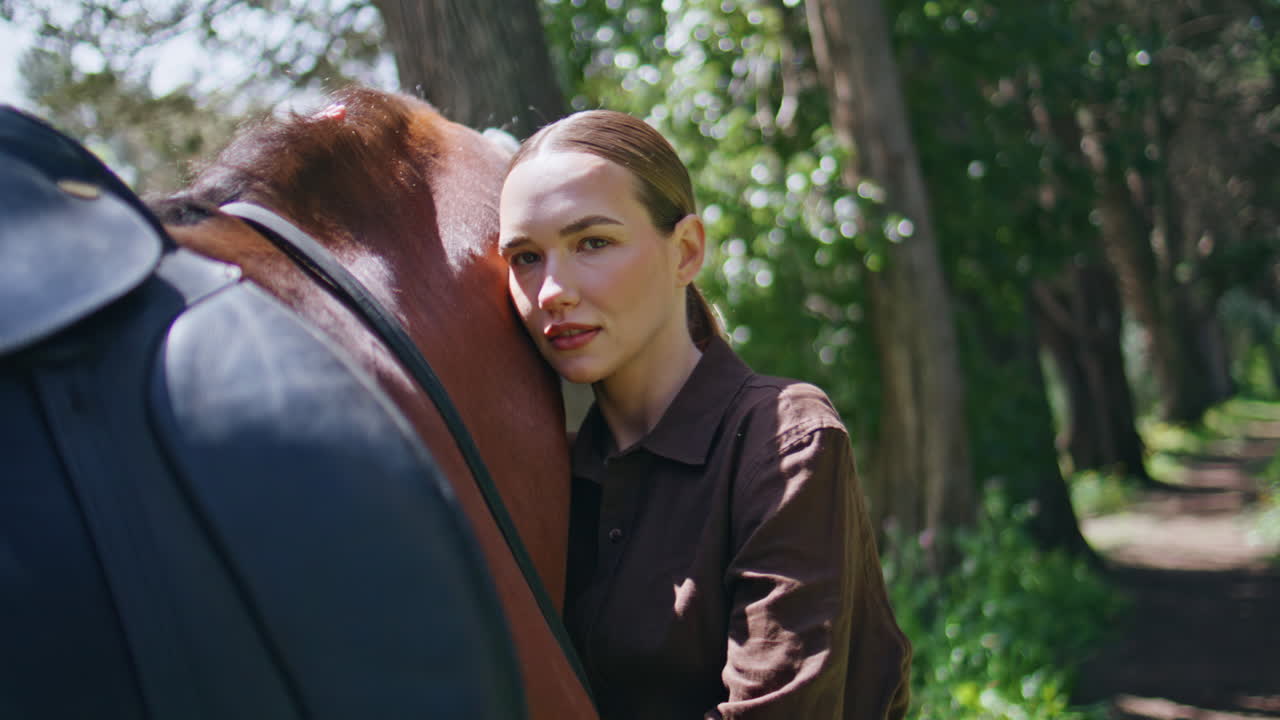 Tender model embracing horse on nature portrait. Smiling woman looking camera