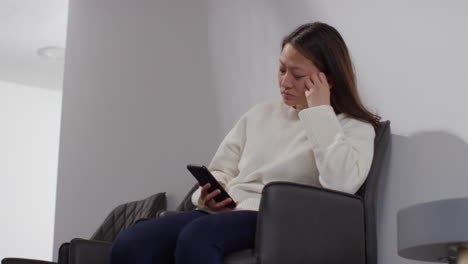 Stressed-Or-Anxious-Woman-At-Work-In-Office-Building-Reacting-To-Internet-Or-Social-Media-News-Message-Or-Story-On-Mobile-Phone-9