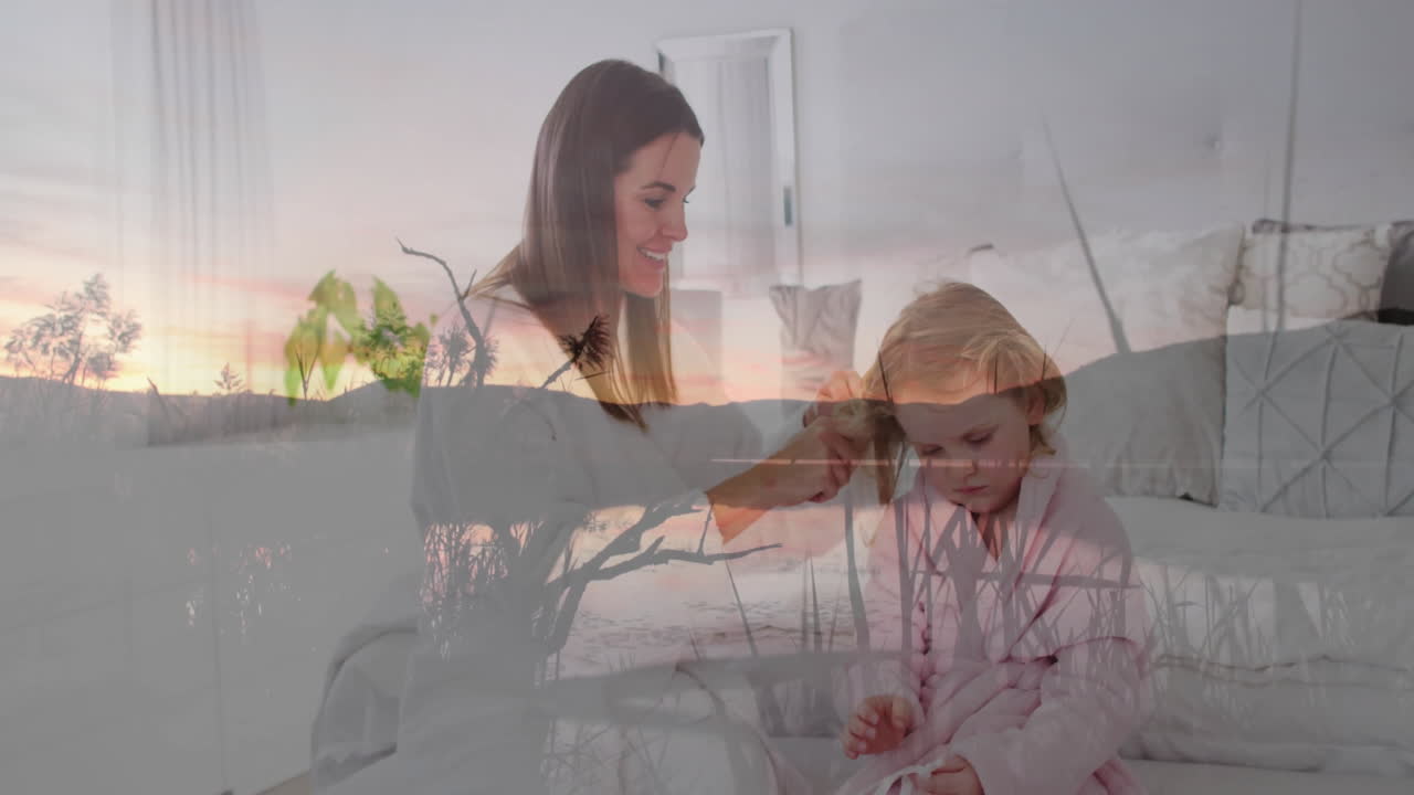 Brushing daughter's hair, mother enjoying sunset in peaceful outdoor setting