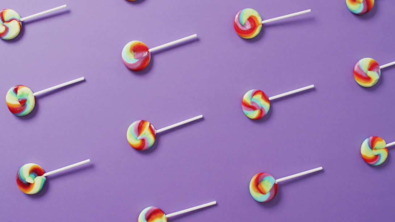 vídeo de filas de piruletas multicolores sobre un fondo azul