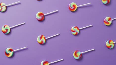 video of rows multicoloured lollipops on blue background