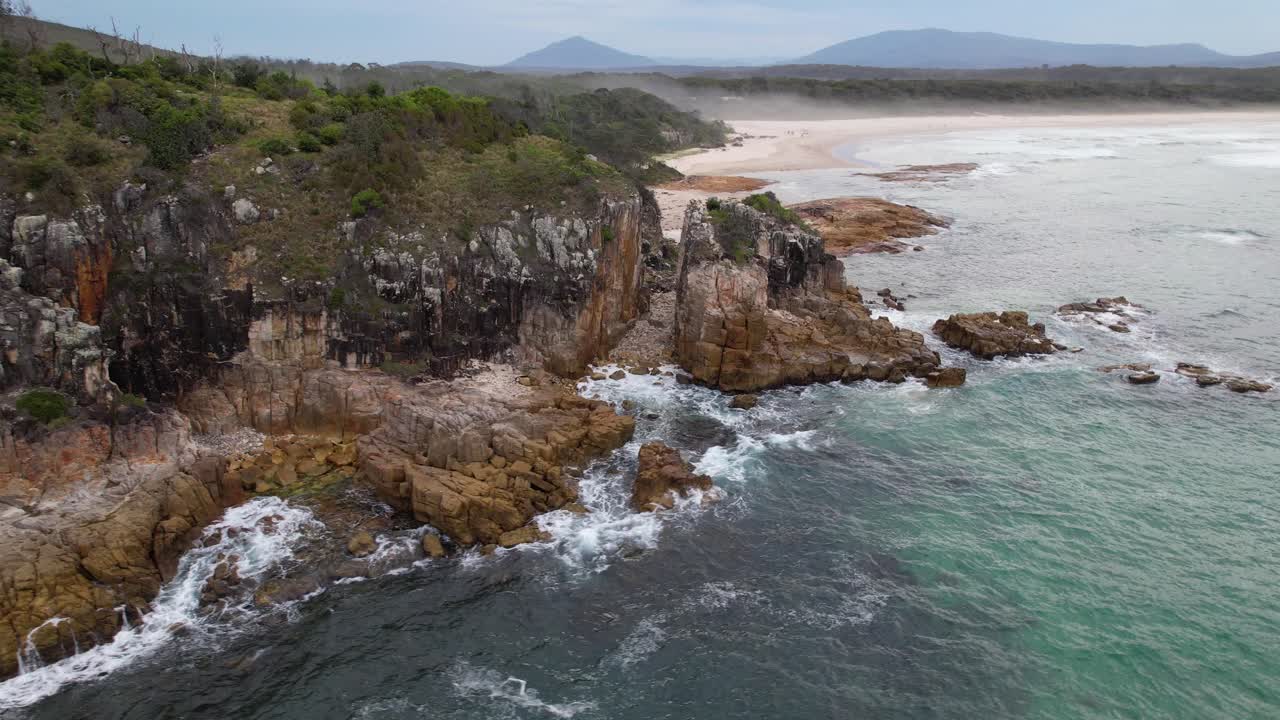 Sea Waves Splashing On Rock Formations Of Diamond Head In New South Wales, Australia. orbiting drone shot
