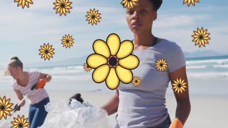 Animation-Von-Blumen-über-Einer-Biracial-Weiblichen-Freiwilligen,-Die-Am-Strand-Müll-Aufsammelt