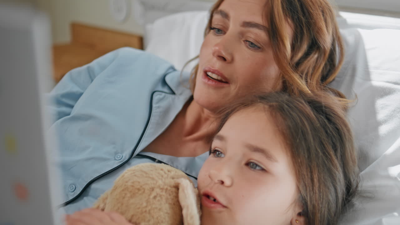 Reading mom child communicating at cozy bed closeup. Woman reading for girl