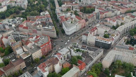 Orbit-tilt-down-shot-of-traffic-on-Rosenthaler-Platz.-Aerial-view-of-square,-important-intersection-in-city.-Berlin,-Germany.