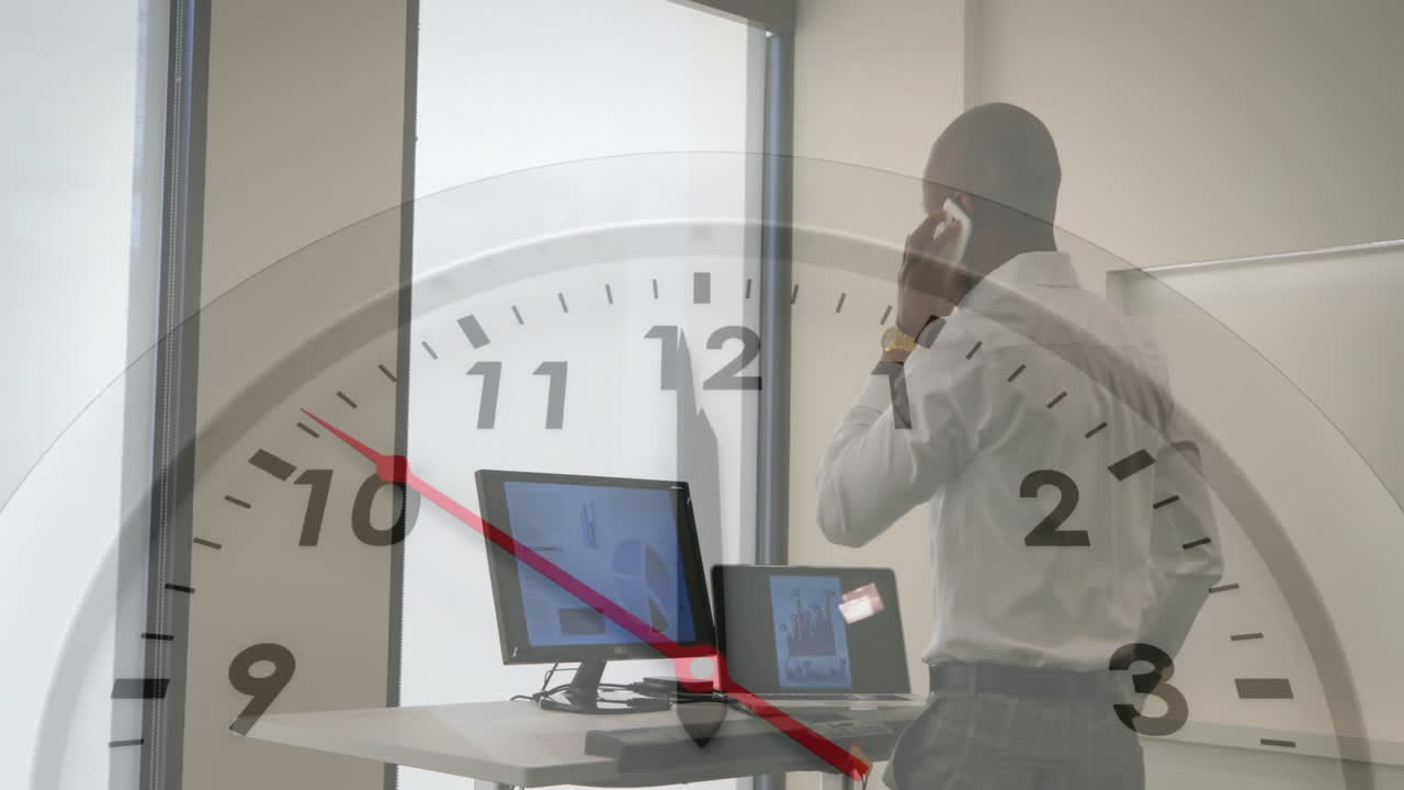 animación de un reloj moviéndose sobre un hombre de negocios biracial hablando en su teléfono inteligente en la oficina