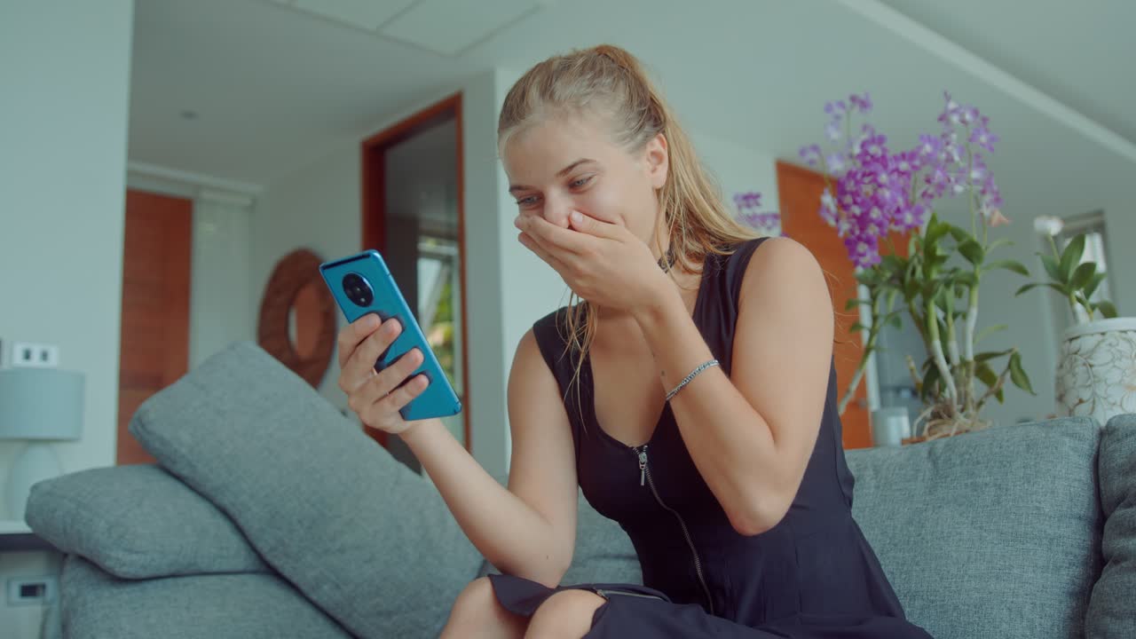 Woman looking at her phone and laughing