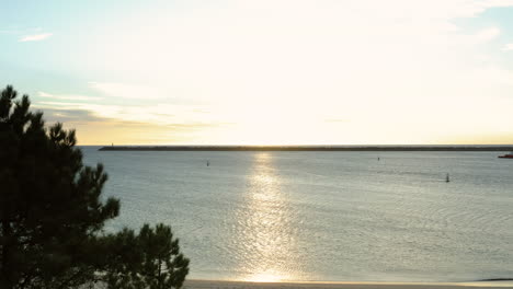 vista sobre el muelle de piedra de la playa de coral desde el lado de la playa de cabedelo al atardecer - toma aérea ascendente