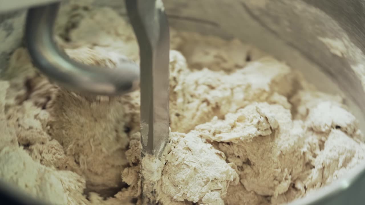 기계는 최신 베이커리에서 호밀 빵에 반죽을 섞습니다.