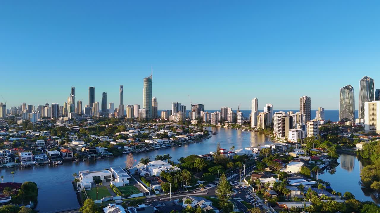 Drone captures dynamic views of Gold Coast's skyline and waterways during sunset, highlighting urban architecture and serene natural beauty