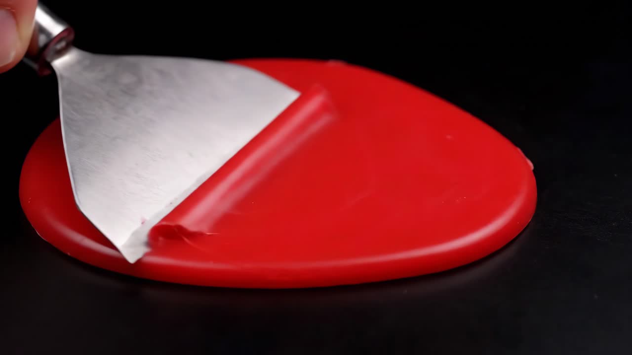 Peeling red candy with a spatula
