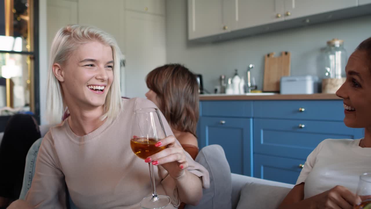 Blonde adult girl talking with friends at the house party