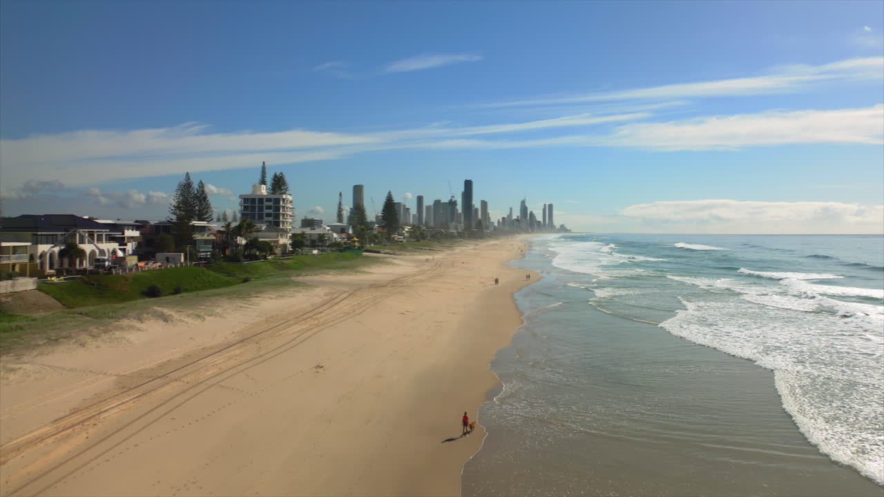 Luftaufnahme eines Strandes mit Stadtsilhouette im Hintergrund