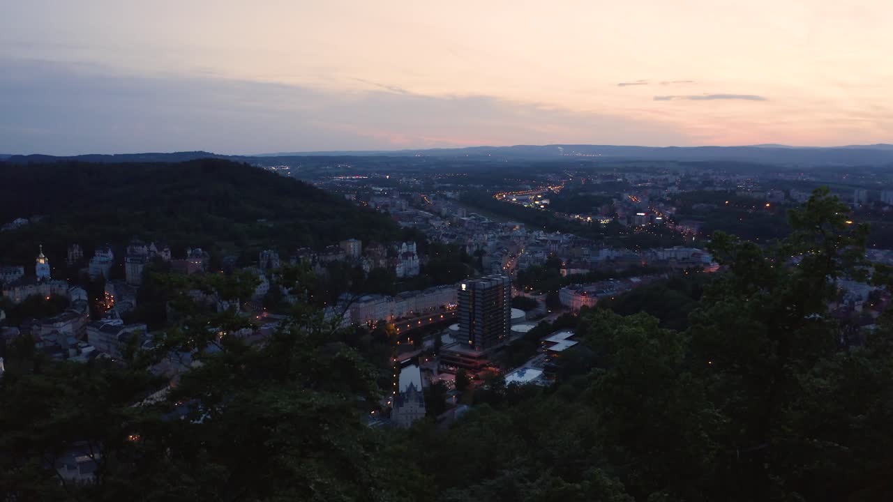 Cityscape at Sunset Viewed from a Forested Hill