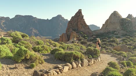 Female-traveler-walking-on-tourist-trail-in-Teide-national-park,-Spain