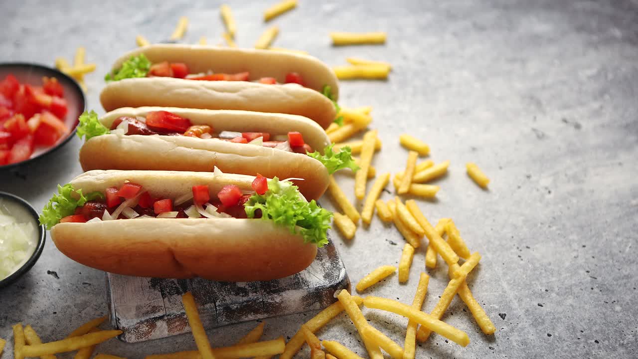 surtido de tres perritos calientes sabrosos colocados en una tabla de cortar de madera