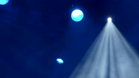 el foco a través del humo en el escenario. equipo de iluminación. luces de efecto. escáner. cambiadores de color. yugo móvil. cabeza móvil