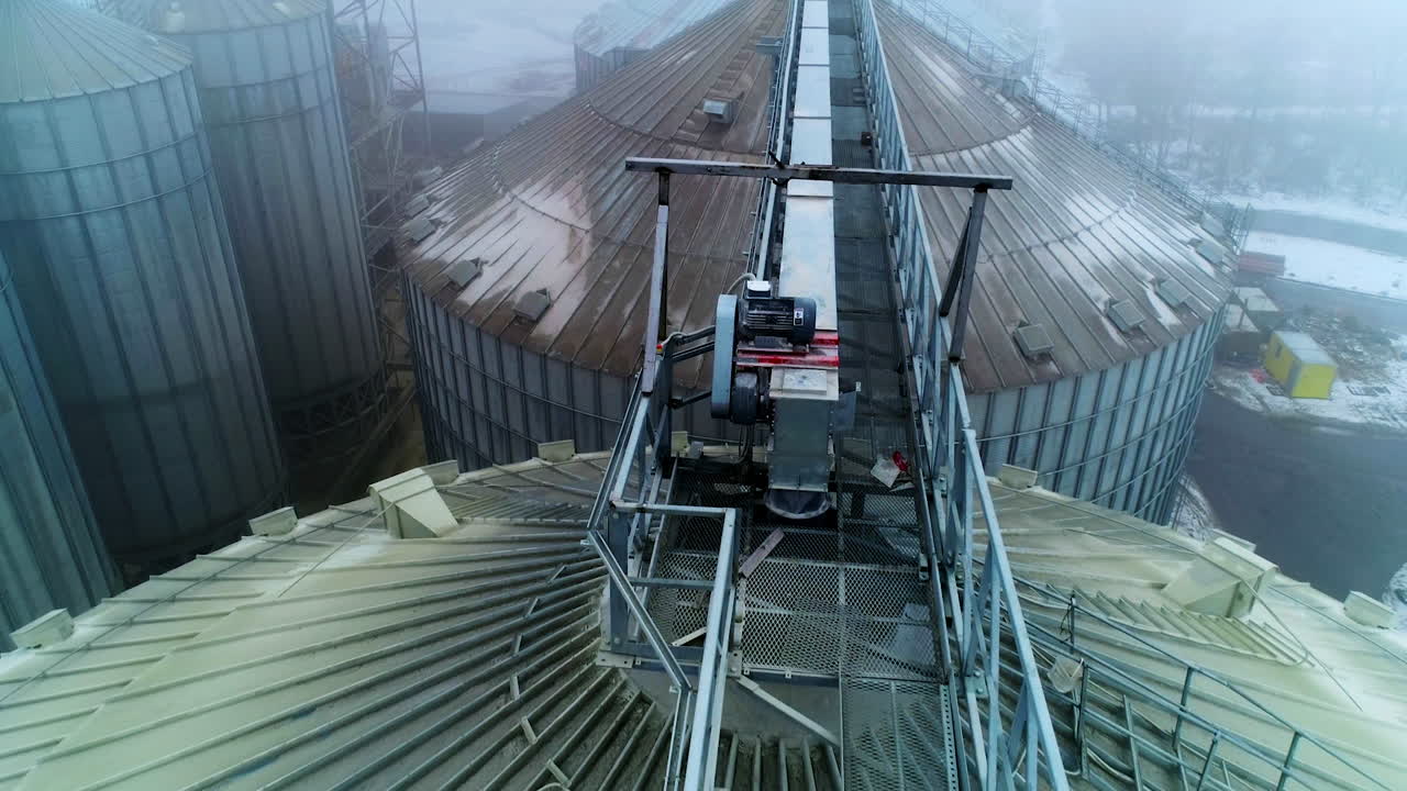 Metal passages between the huge tanks of grain elevator. Number of granary elevator cisterns standing close to each other at agribusiness plant.
