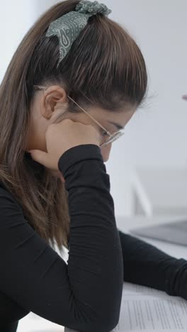 young woman intently studying or working at a desk