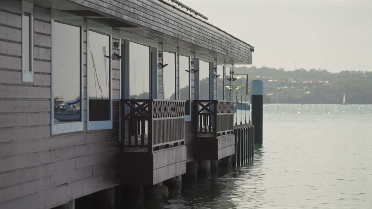 Close side view of the Double Bay ferry wharf building extending over Sydney Harbour,