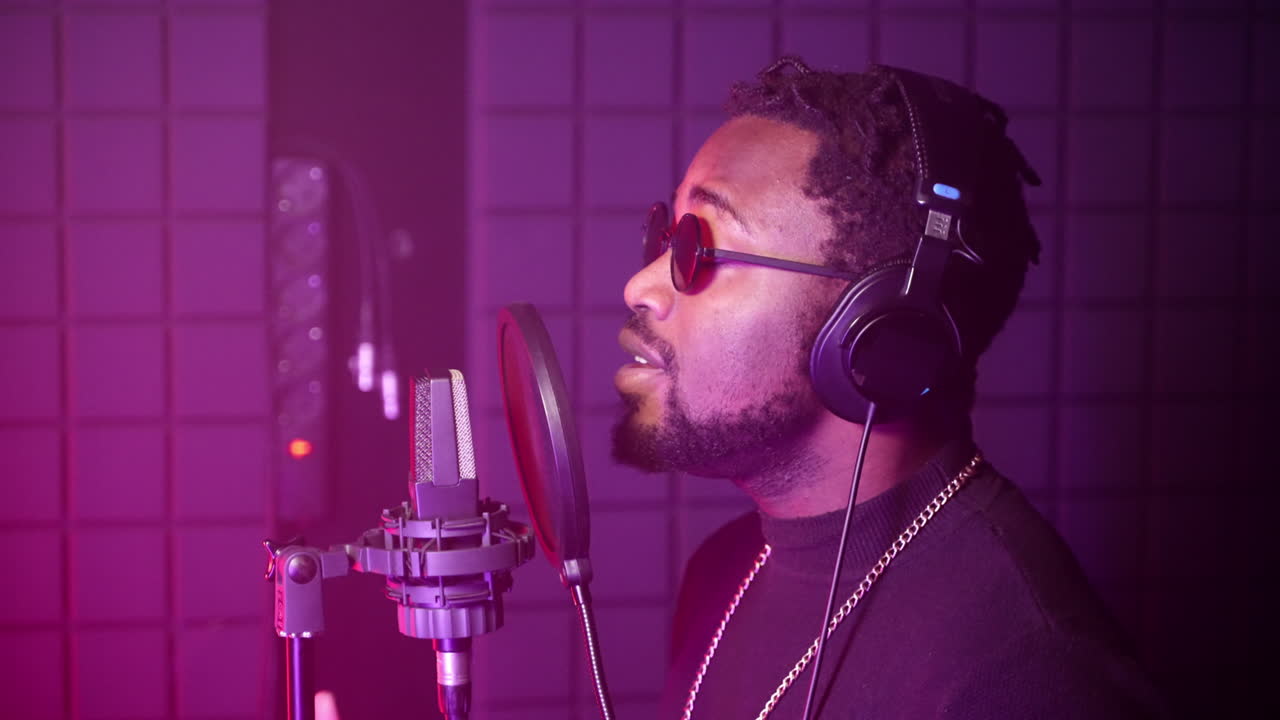 hombre cantando en un micrófono en un estudio de grabación