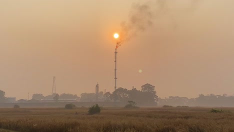 Establecedor-Amplia-Toma-De-Puesta-De-Sol-Brumosa-Con-Planta-De-Torre-De-Gas-En-Llamas,-Liberación-De-Humos