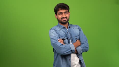 handsome asia male standing with folded hands for a photo shoot in front of green screen