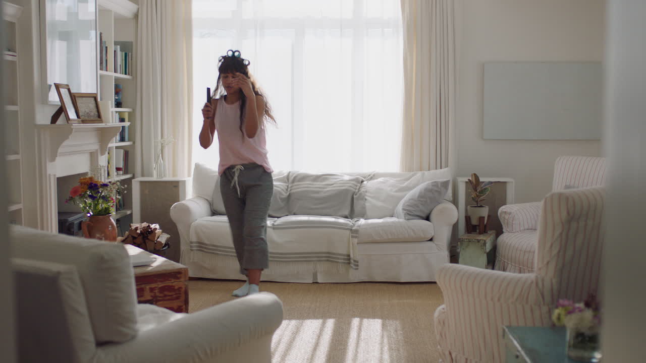 junge frau singt zu hause, hat spaß, tanzt, genießt karaoke-musik, feiert am wochenendmorgen