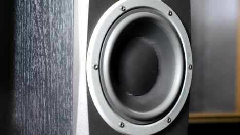 close up of moving sub-woofer on recording studio. black speaker pulsating and vibrating from listen of loud music on low frequency. working of modern high fidelity loudspeaker membrane. slow motion