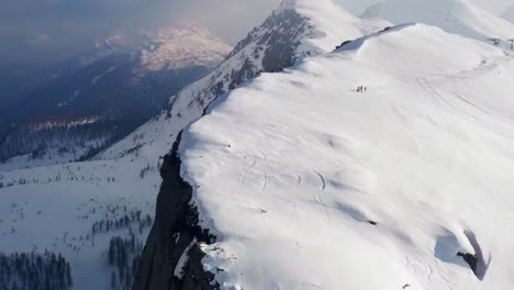 Vista-Aérea-Cinematográfica-Sobre-Cuatro-Excursionistas-Escalando-Passo-Rolle-O-Rolle-Pass-Con-Nieve