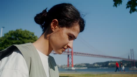 woman working on laptop in a park by the bridge