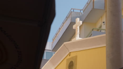 christian cross on a roof in a street