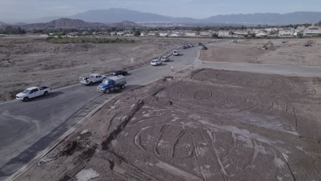 un dron observa un camión de agua mientras pulveriza agua para preparar el suelo en un sitio de construcción de una casa