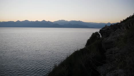 full shot, sea waves on the side of the cliff, scenic sunset over the mountain range in antalya, turkey