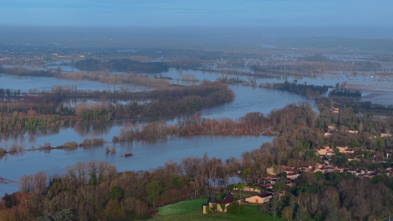Vista aerea di vigneti allagati che riflettono il cielo, con alberi che emergono dall'acqua, creando un netto contrasto con il paesaggio sommerso, Paillet, Francia