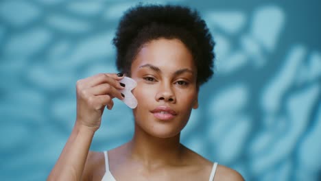 mujer realizando masaje facial de gua sha