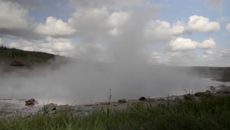 Dampfende-Geothermische-Quelle,-Island-Mit-Bewölktem-Himmel-Und-Grasbewachsenem-Vordergrund
