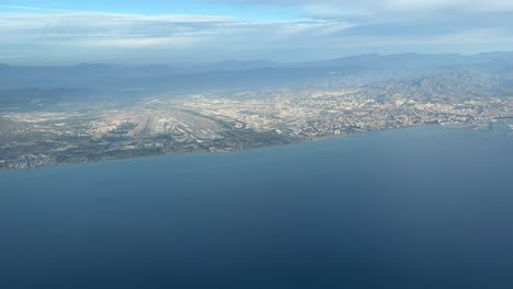 Vista-Panorámica-Aérea-De-La-Ciudad-De-Málaga-Y-Su-Aeropuerto,-España,-Tomada-Desde-Una-Cabina-De-Avión-Durante-La-Salida-Del-Aeropuerto.